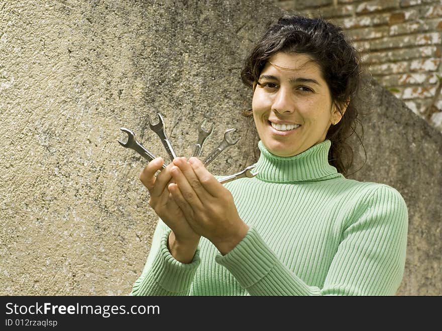 Smiling woman holding five wrenches. Vertically framed photo. Smiling woman holding five wrenches. Vertically framed photo.