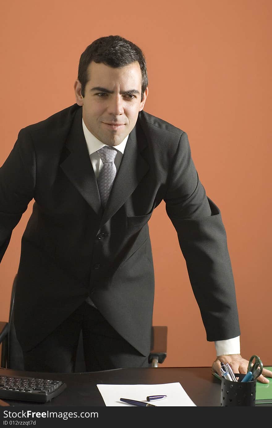 Businessman Standing Over His Desk - Vertical