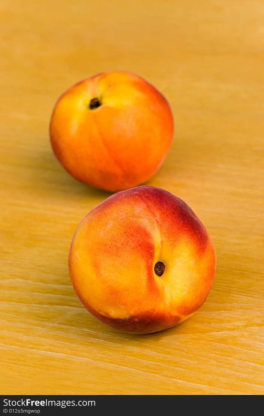 Two ripe nectarines on the wooden background