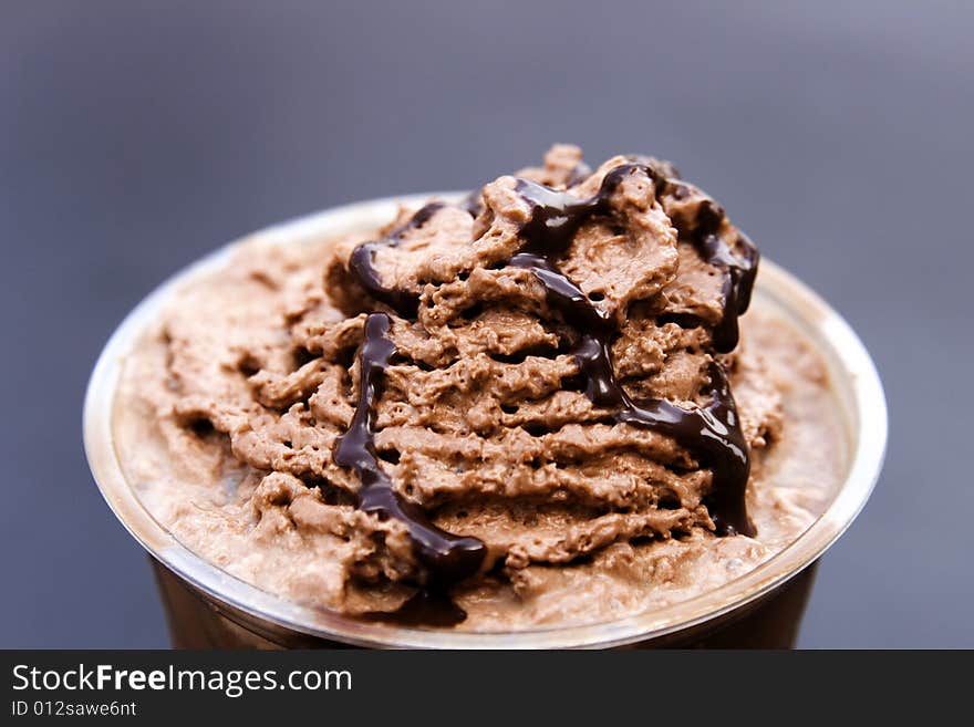 Frappuccino with chocolate whip cream on top shot against blue background. Frappuccino with chocolate whip cream on top shot against blue background.