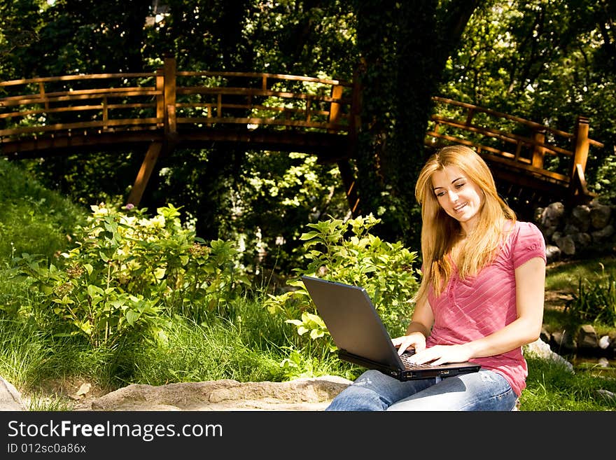 Beautiful young student using laptop in natural environment. Beautiful young student using laptop in natural environment.