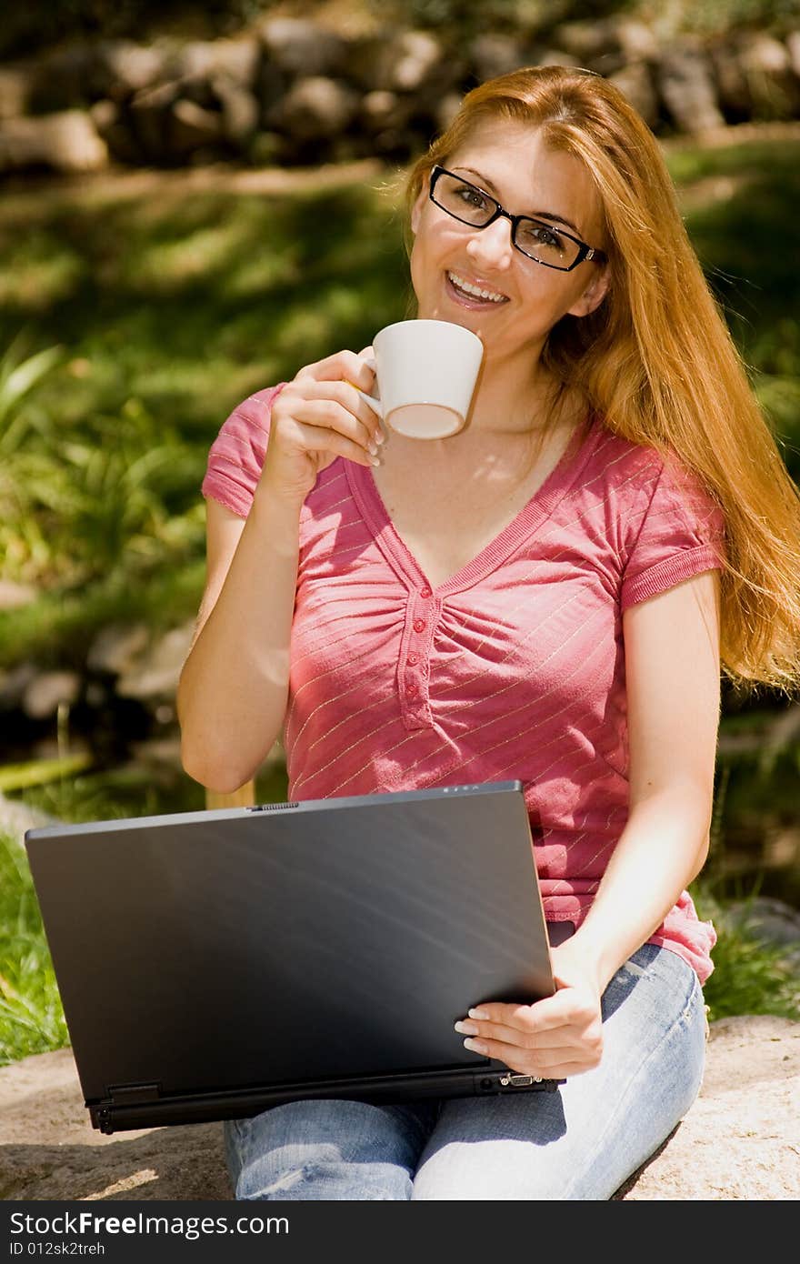 Beautiful young student using laptop and drink coffee in natural environment. Beautiful young student using laptop and drink coffee in natural environment.