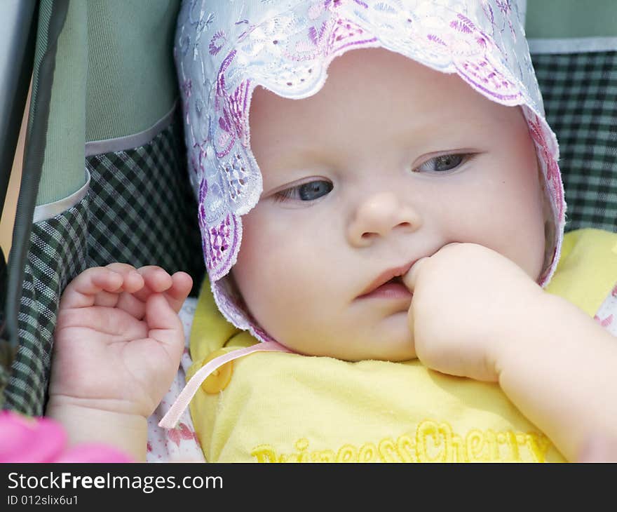 Portrait of 6 month baby holding finger at mouth