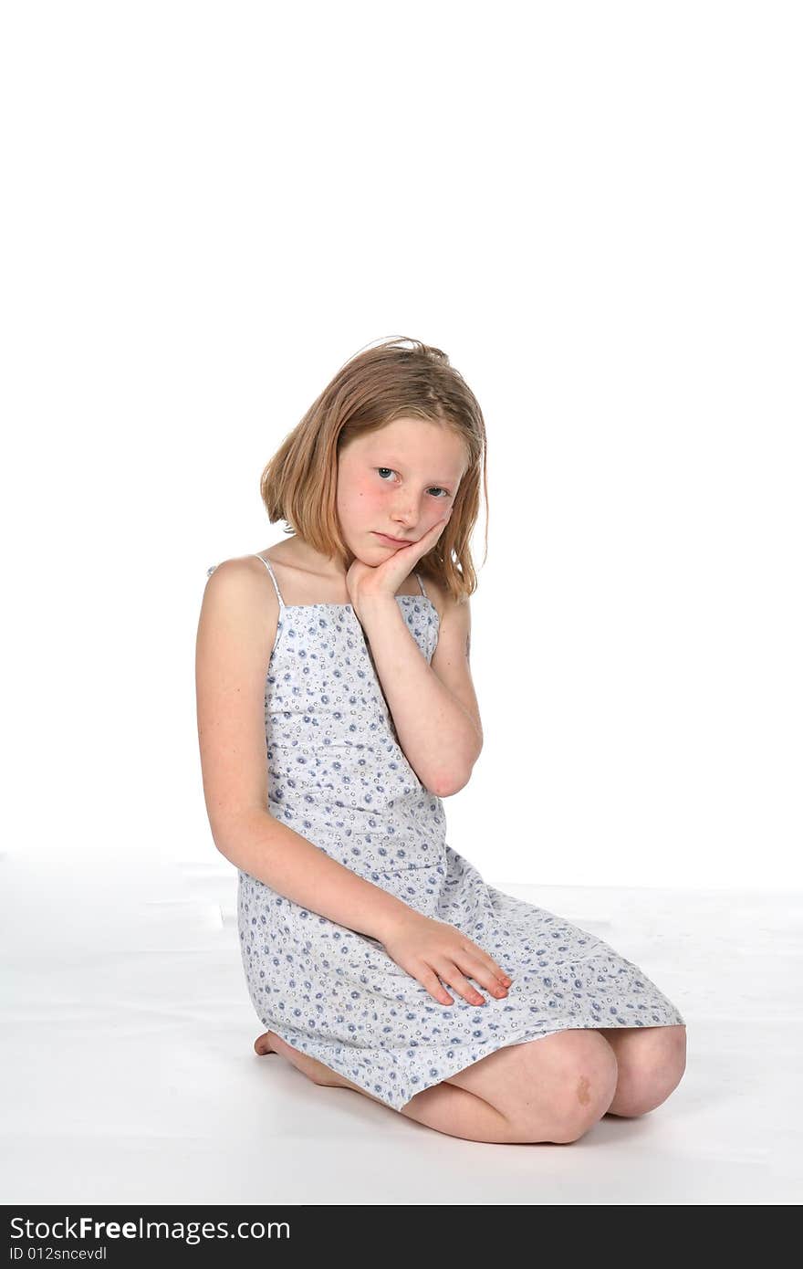 Pretty girl in dress kneeling and pouting. Pretty girl in dress kneeling and pouting