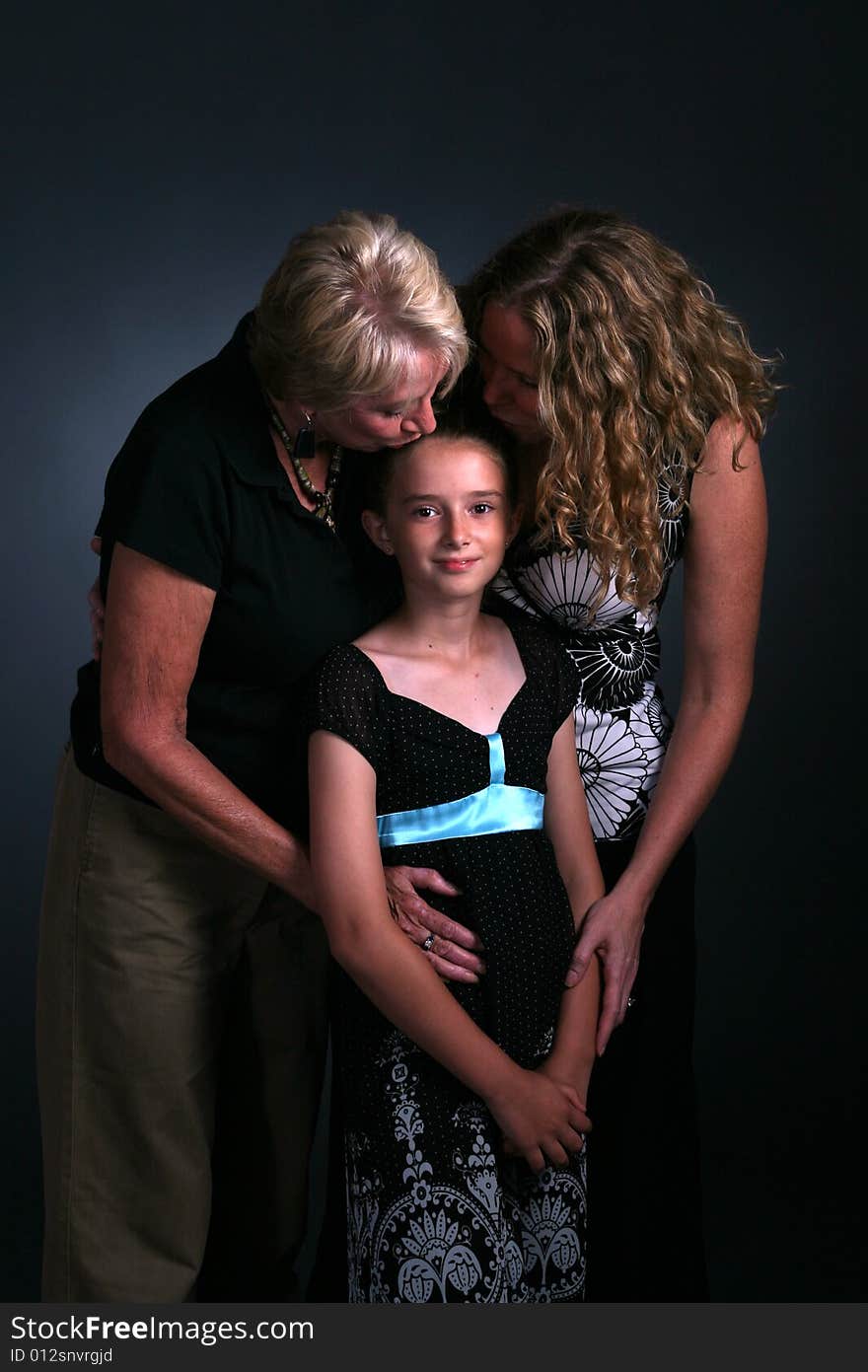 Three generations of women with child being kissed. Three generations of women with child being kissed