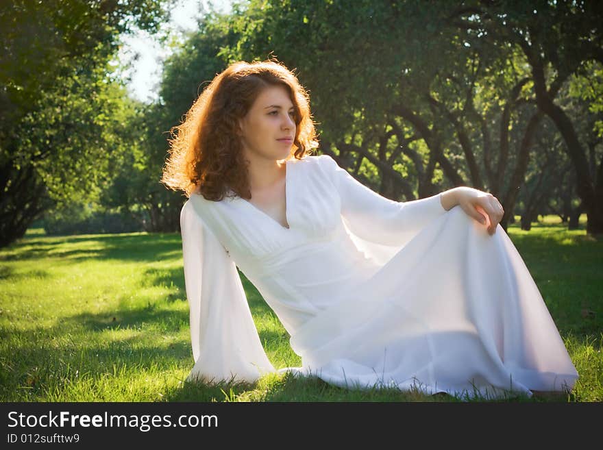 Young woman sit on meadow in garden. Young woman sit on meadow in garden