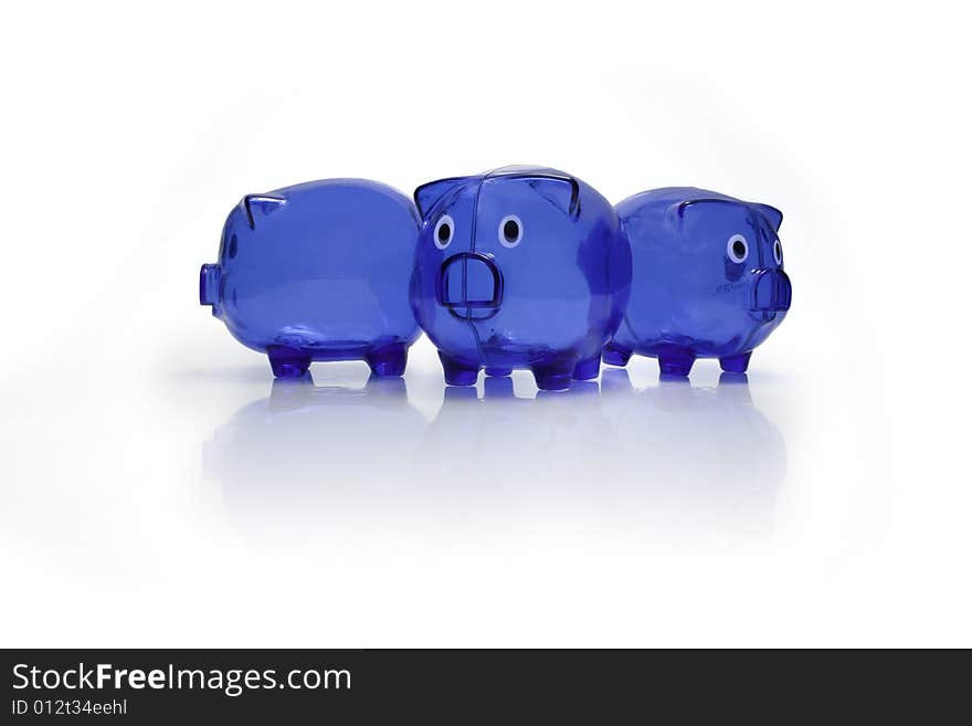 Three blue plastic piggy banks with a shadow and a reflection on a white seamless background. Three blue plastic piggy banks with a shadow and a reflection on a white seamless background.