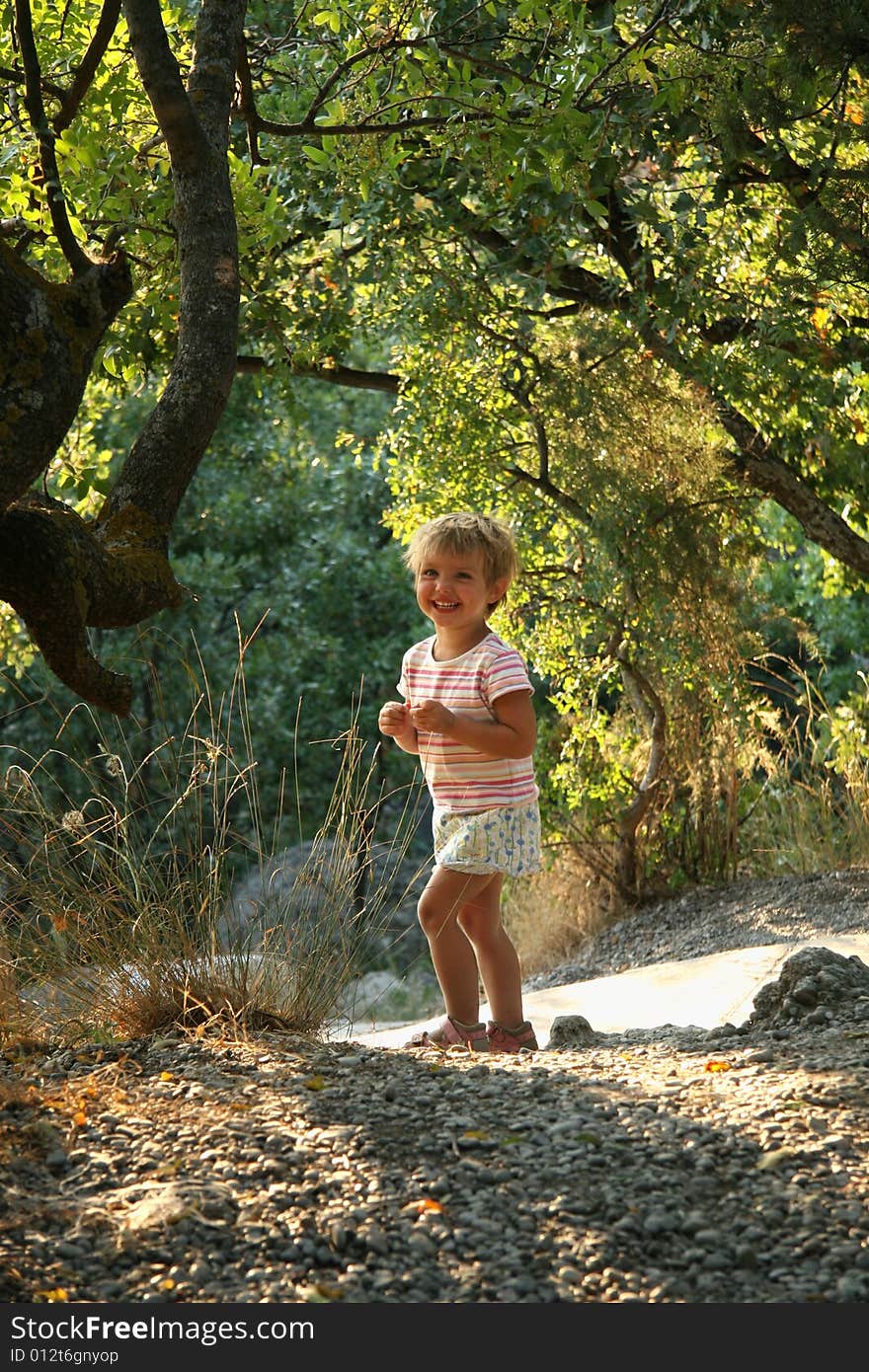 The laughing little girl walks in park