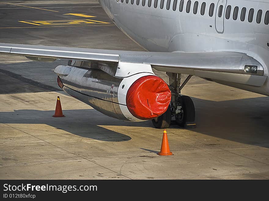 Parked & secured for the evening. This jet engine is carefully covered with a red plastic covering, as well as the orange witch hats, to assist in marking off the off limits zone, for pedestrian traffic. Parked & secured for the evening. This jet engine is carefully covered with a red plastic covering, as well as the orange witch hats, to assist in marking off the off limits zone, for pedestrian traffic.