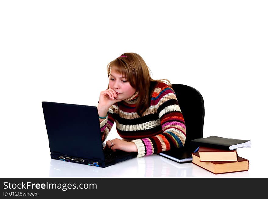 Teenager student doing homework with laptop and books on desk, with background, reflective surface