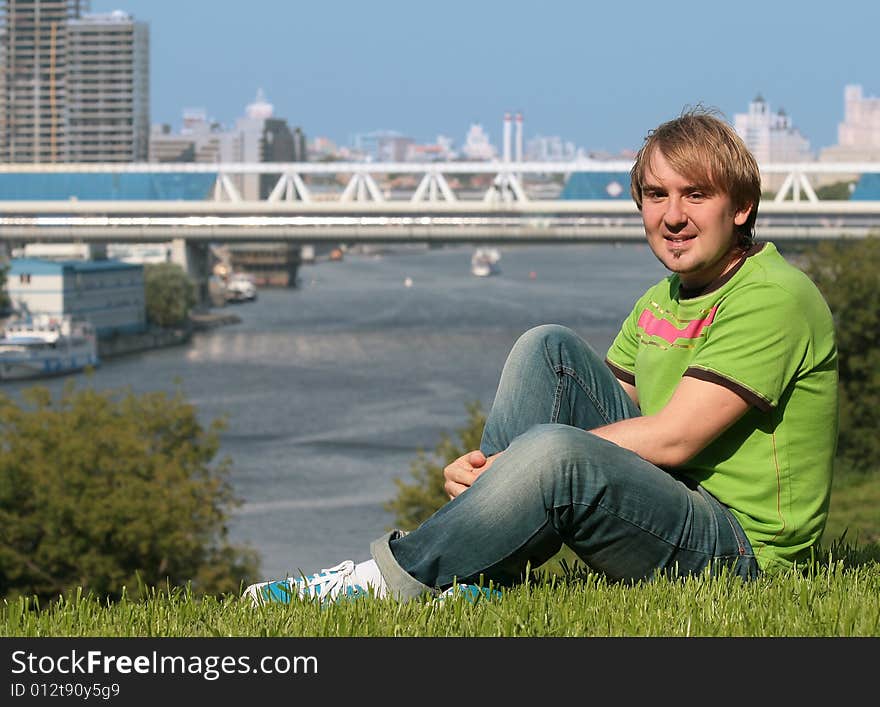 Happy young man sitting on the grass