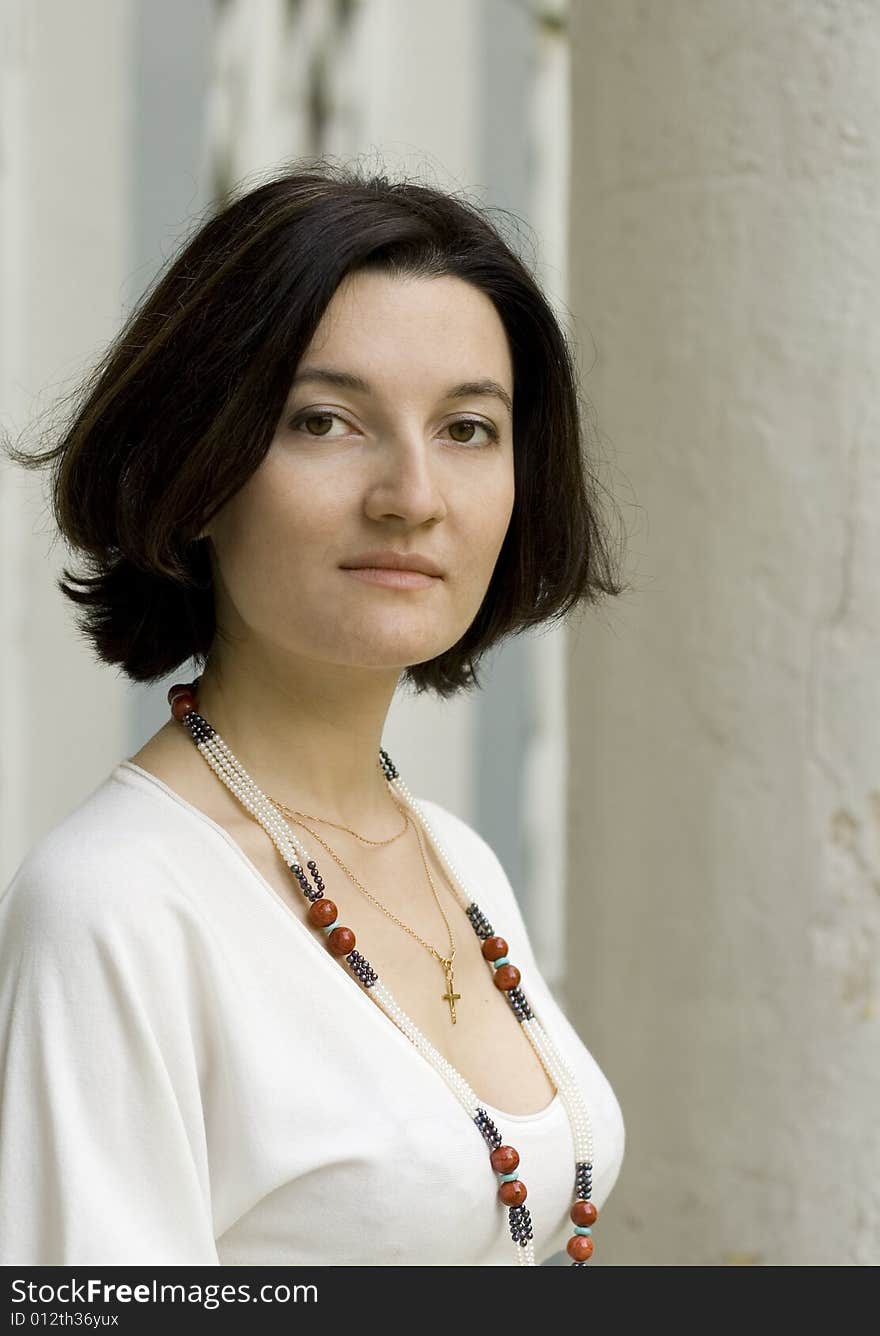 Portrait of pretty woman standing near white column