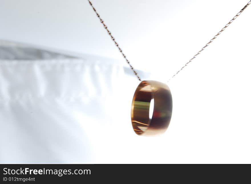 The wedding ring suspended on the shaken chain. The wedding ring suspended on the shaken chain.