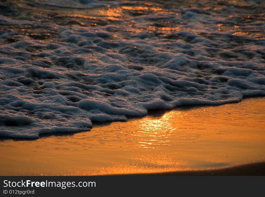 Sunset reflection on the sand with sea foam taken in lebanon near byblos