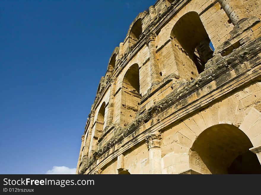 Part of an old amphitheatre against the blue sky. Part of an old amphitheatre against the blue sky