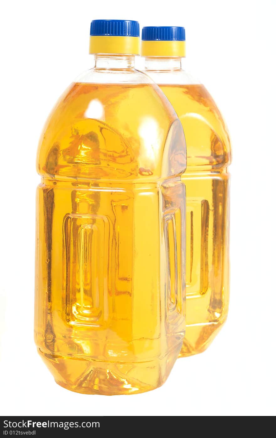 Two bottles filled with sunflower oil. Isolated on a white background. Two bottles filled with sunflower oil. Isolated on a white background.