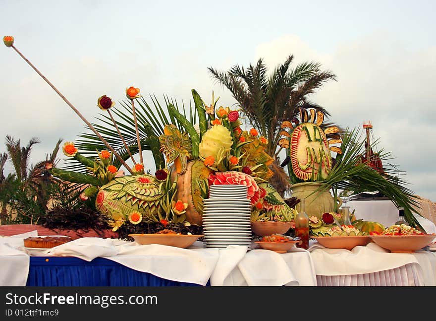 Setup of tropical food and fruits by the pool.