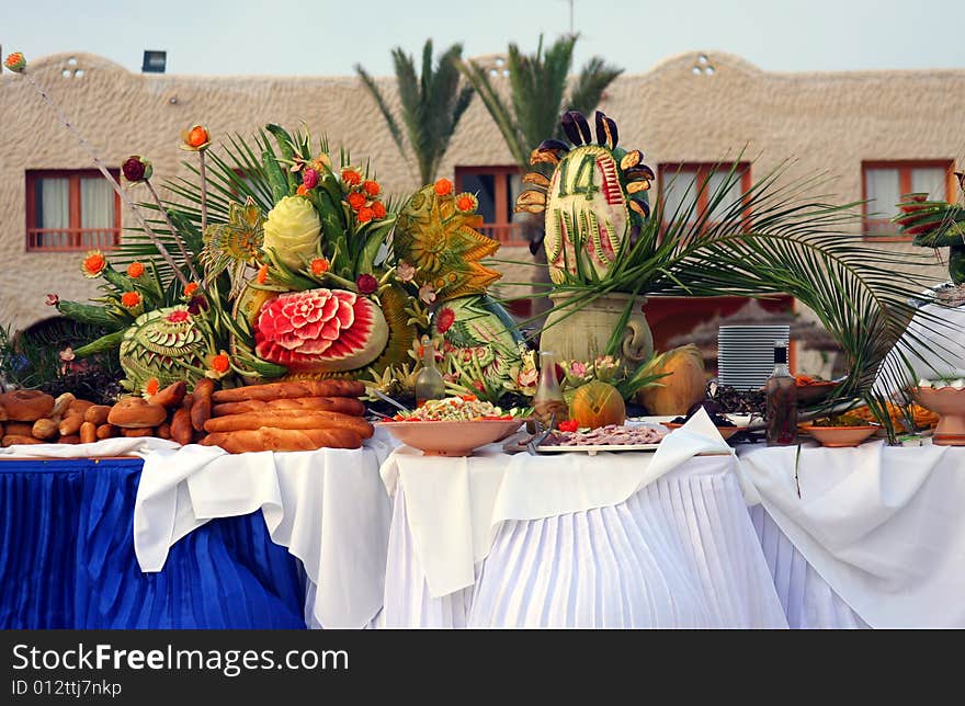 Setup of tropical food and fruits by the pool.