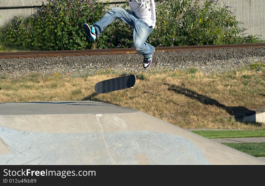 Young Male Skateboarder Doing Tricks at a skate park. Young Male Skateboarder Doing Tricks at a skate park.