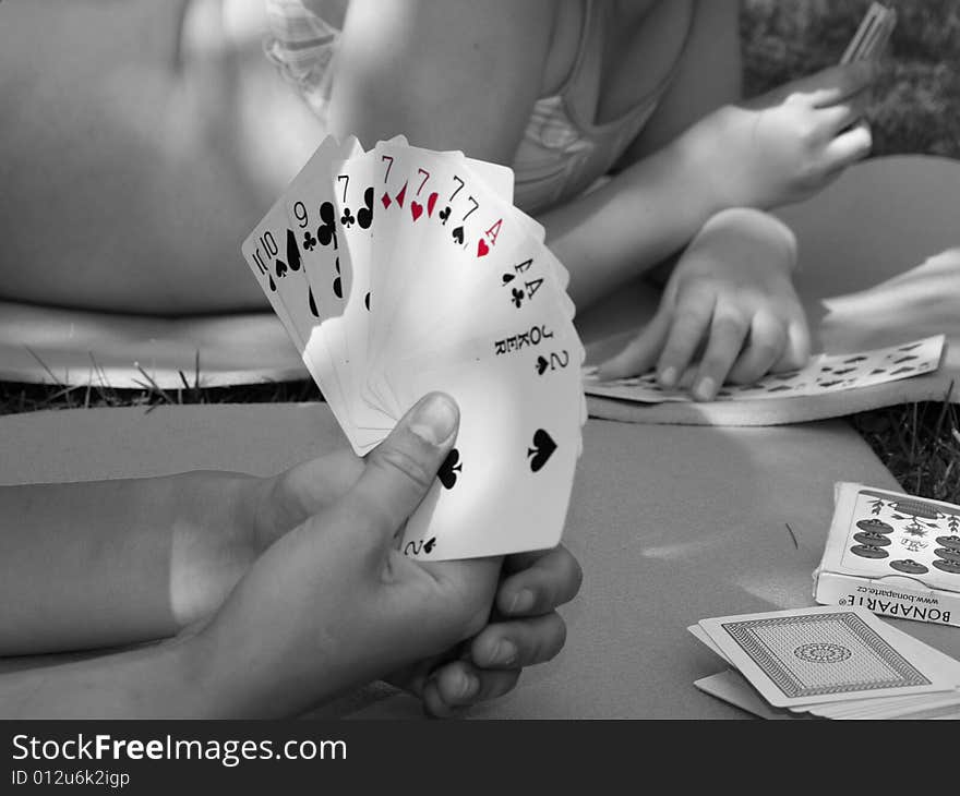 Playing-cards in hand, outdoor scene