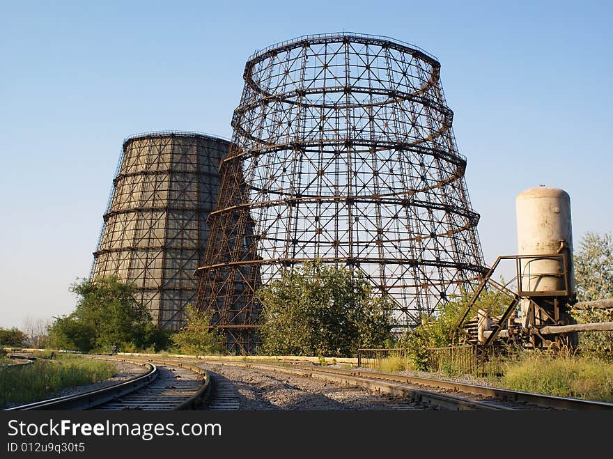 Cooling towers pipe-bridge and railways against blue sky. Cooling towers pipe-bridge and railways against blue sky