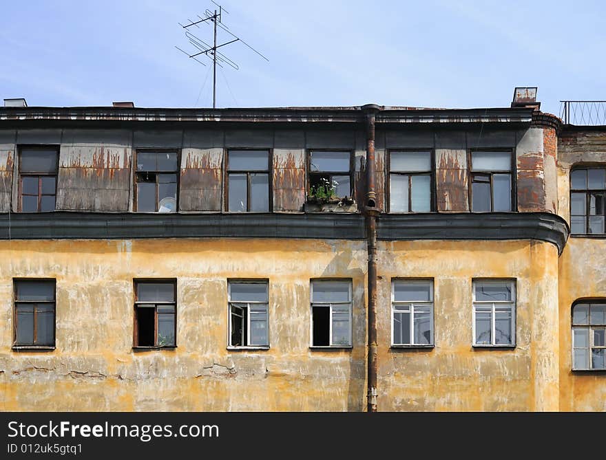 Old house with the peeled off paint and plaster.