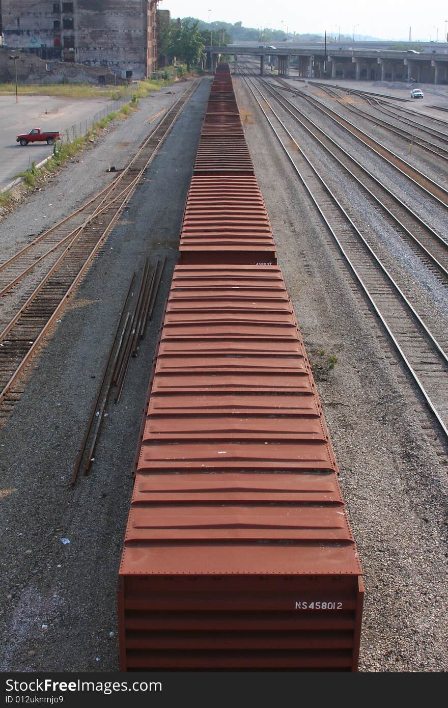 A row of freight cars seems to stretch into infinity as the cars sit in an industrial railway yard in Tennessee on a warm, summer day. A row of freight cars seems to stretch into infinity as the cars sit in an industrial railway yard in Tennessee on a warm, summer day.