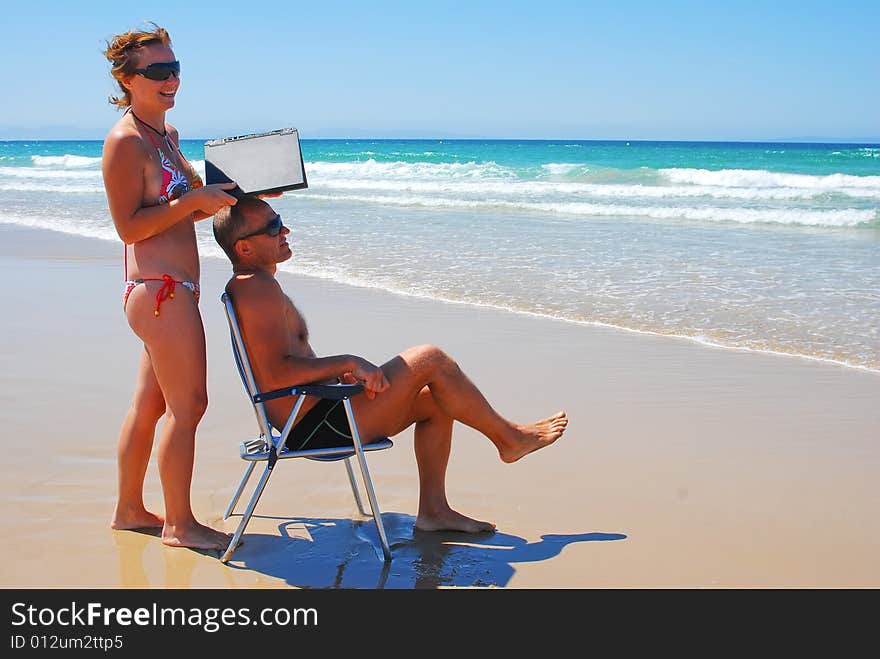 The man and the woman have a rest on coast of ocean. The man and the woman have a rest on coast of ocean