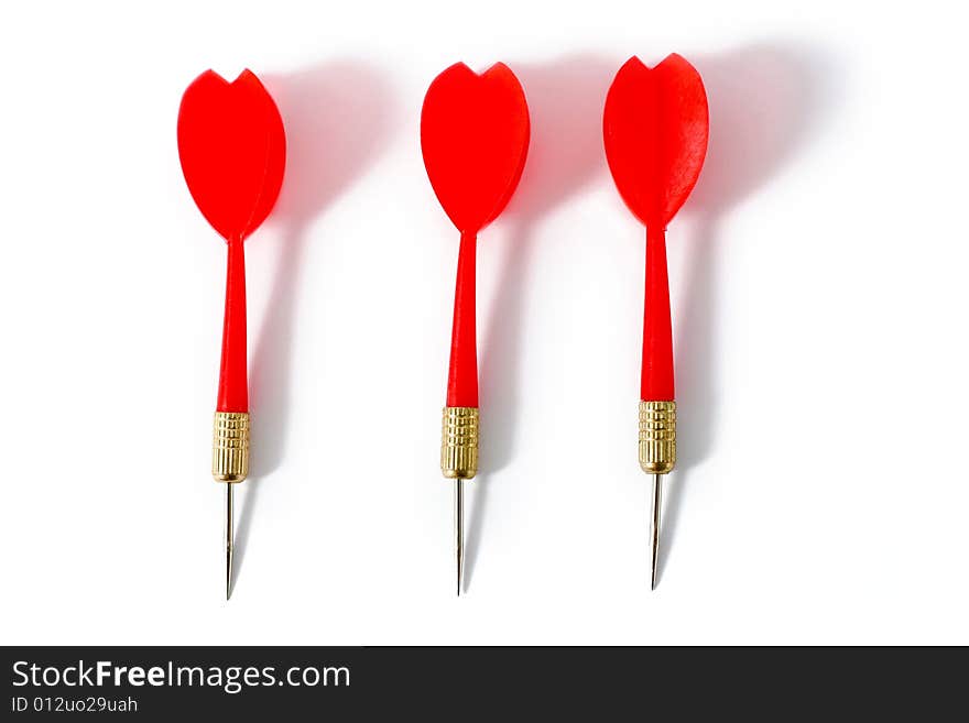 Three red darts close-up on a white surface