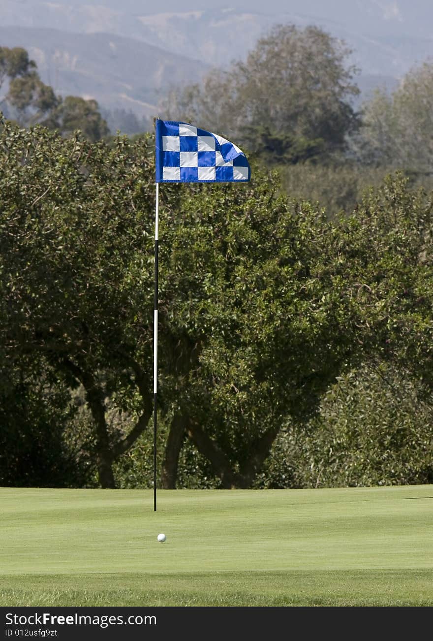 Golf green with ball dropping onto green