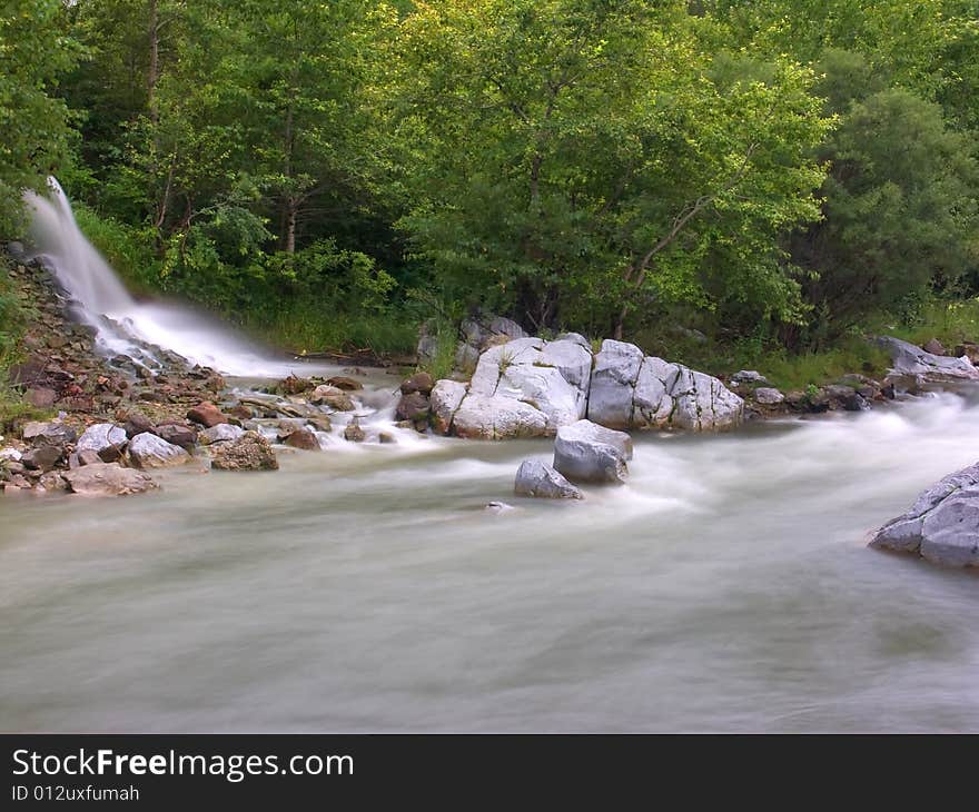 Falls running into the mountain river in Russia