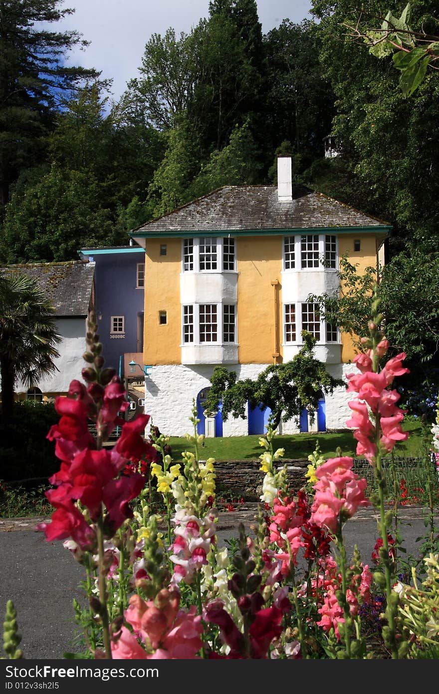 A cottage set in a rural area with flowers growing in front. A cottage set in a rural area with flowers growing in front