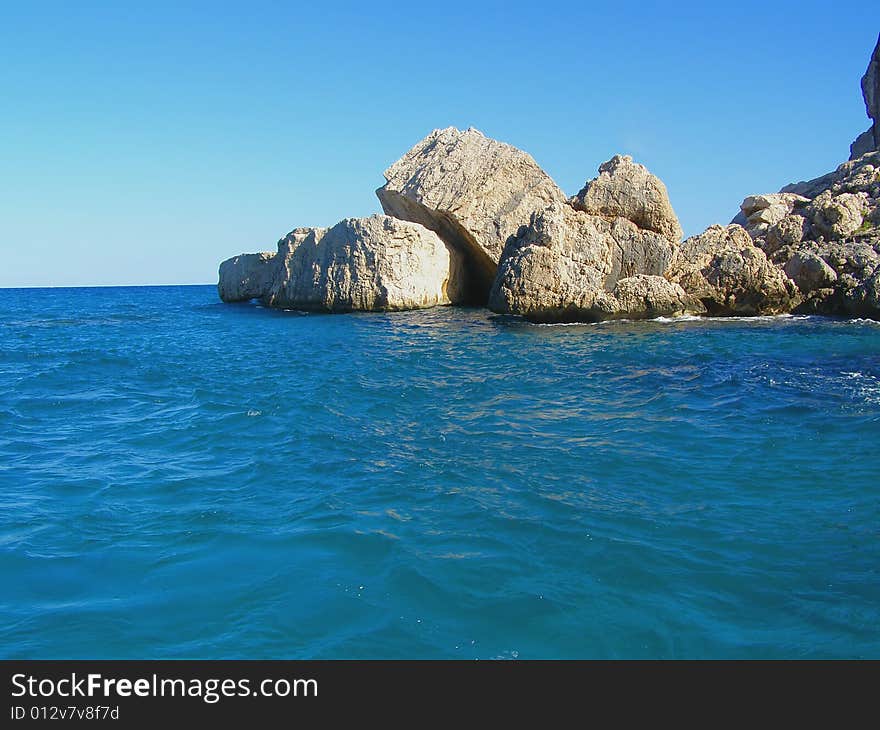 Sea and rocks of beautiful colors, view from the sea and clear-blue sky in Sardinia - Italy