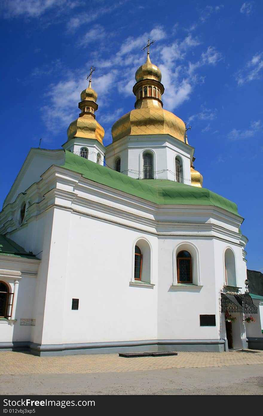 Beautiful church in good weather on a background of the blue sky with white clouds