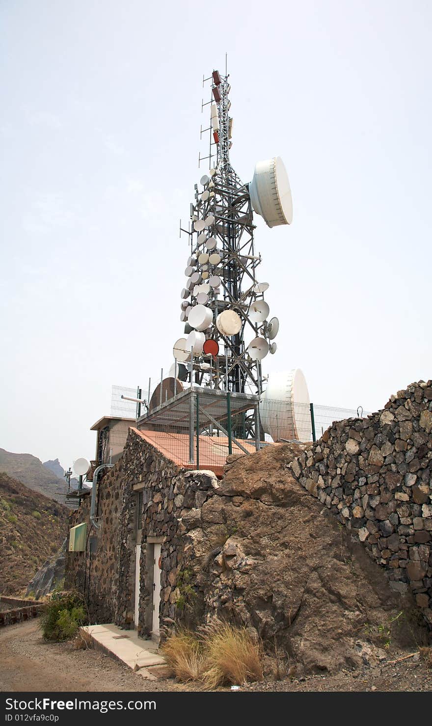 Communications antenna on the roof of a stone house