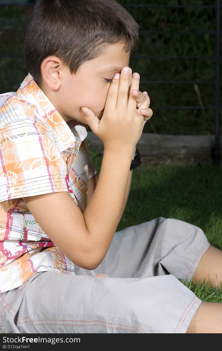 Young boy praying outdoors evening