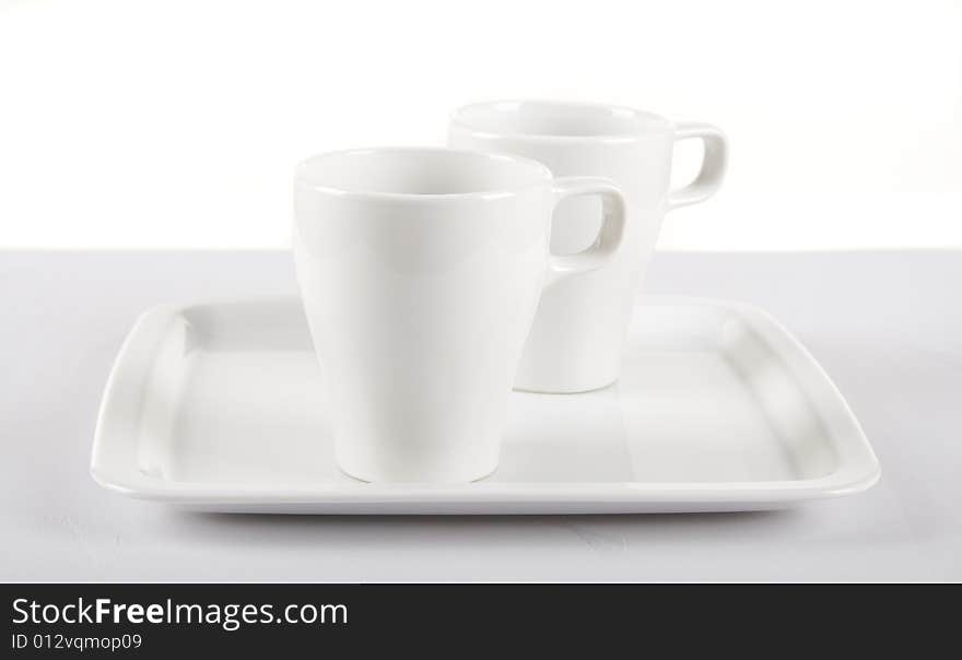 White cups on white plate. White cups on white plate