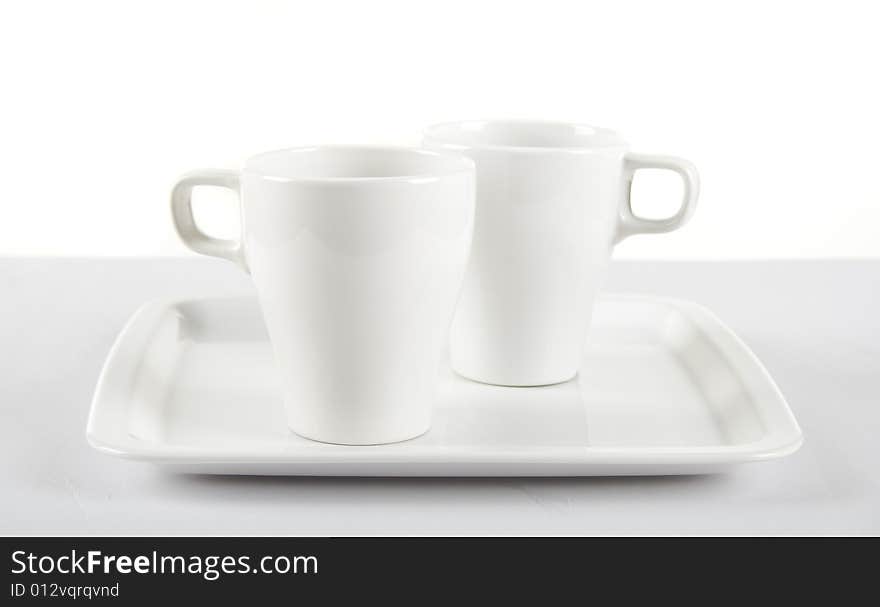 White cups on white plate. White cups on white plate