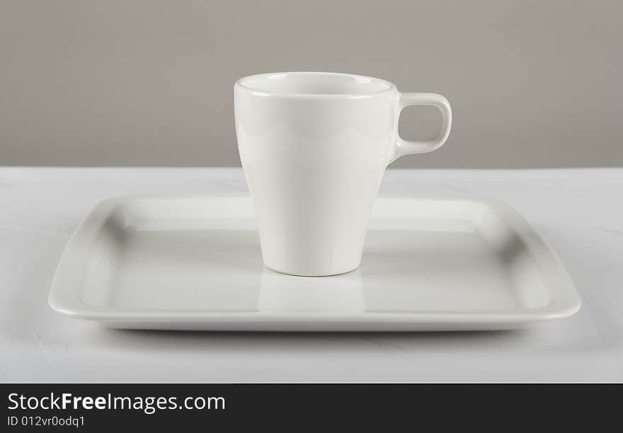 White cup on white plate. White cup on white plate