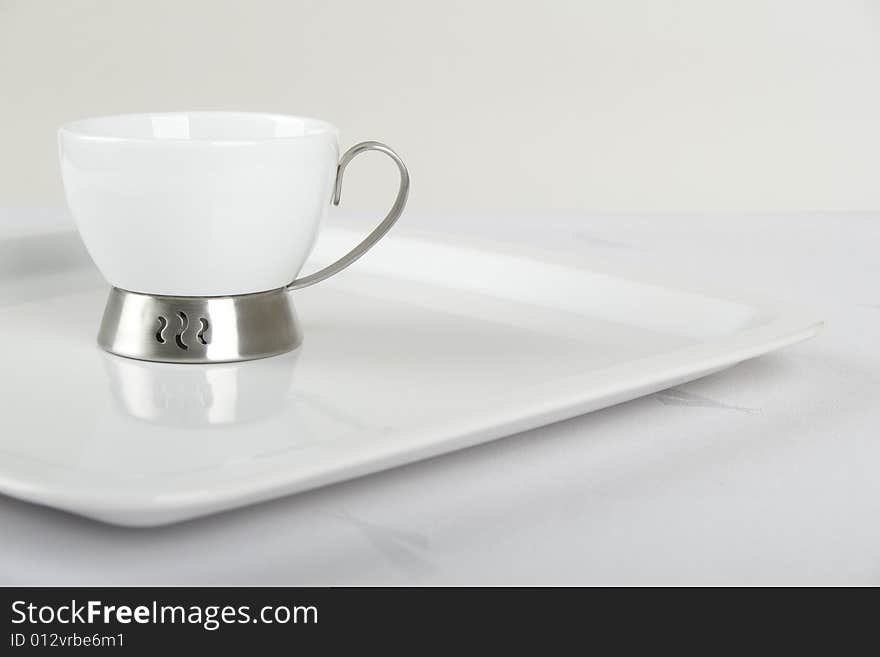 White porcelain cup on white plate