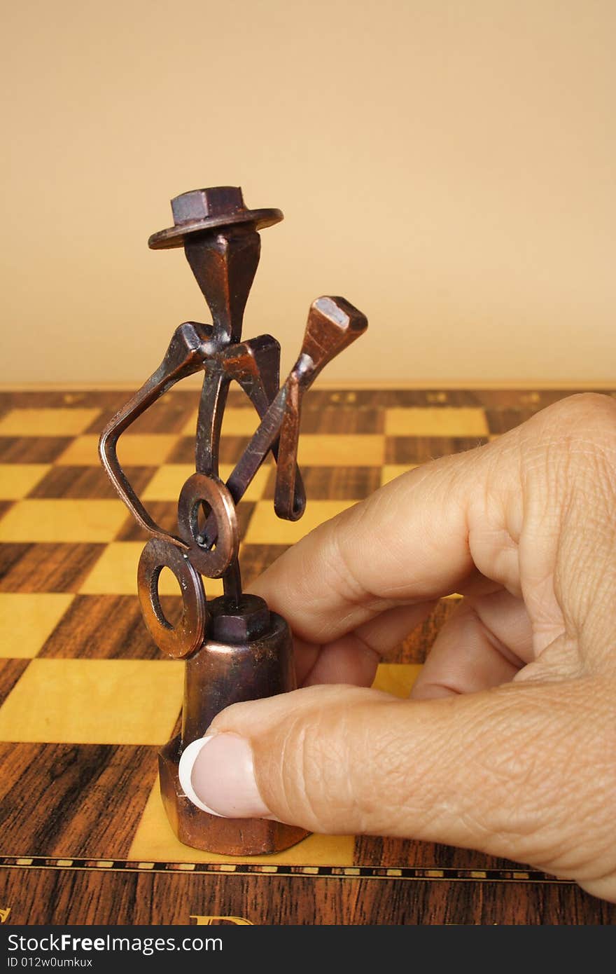 Senior hand holding an iron figure of chess