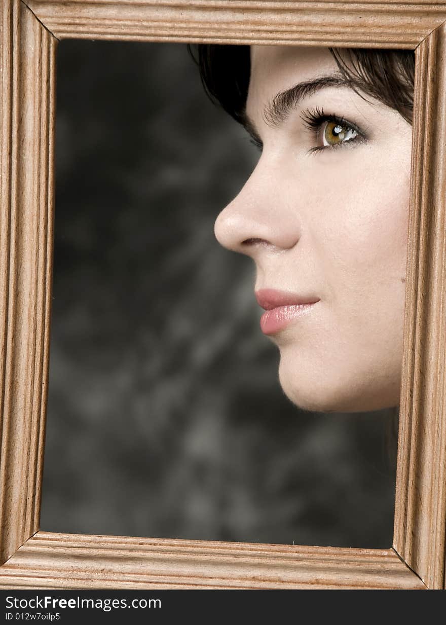 Face of beautiful girl, in a wooden frame