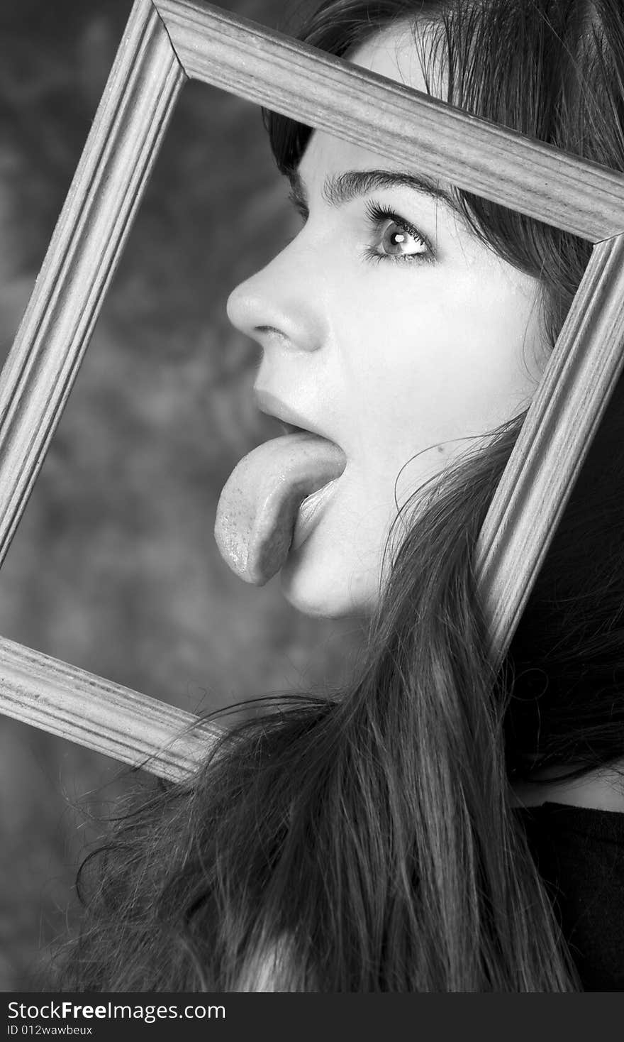 Face of young girl, in a frame from a picture with put out a tongue