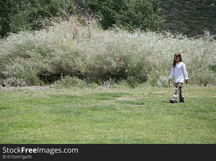 Young child walking across a nature background