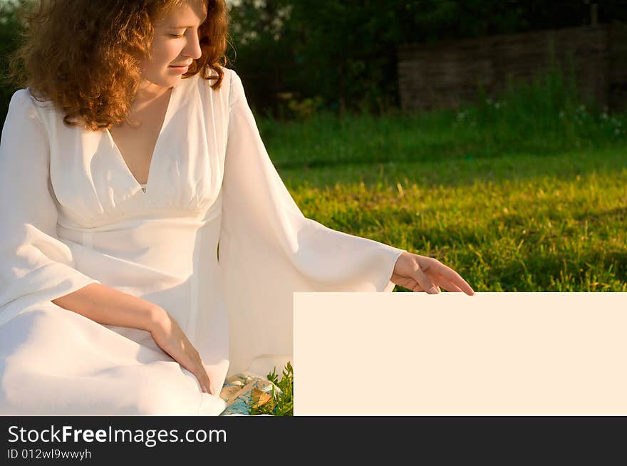 Young girl in white dress sitting on green grass. Young girl in white dress sitting on green grass