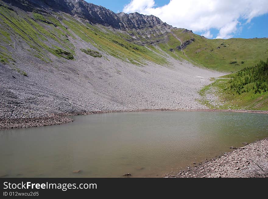 Alpine lake on mountains indefatigable, kananaskis country, alberta, canada