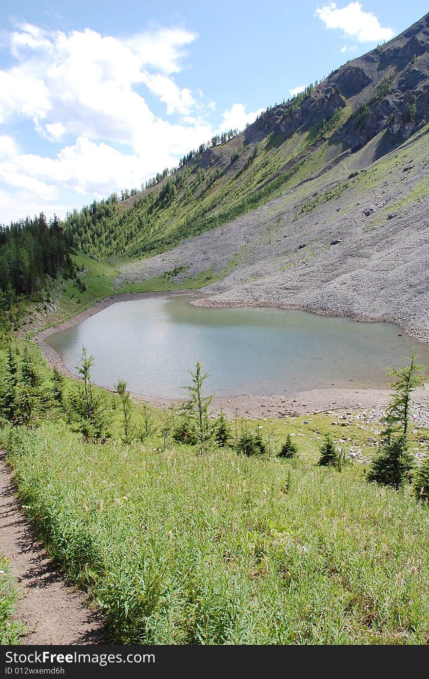 Alpine lake on mountains indefatigable, kananaskis country, alberta, canada