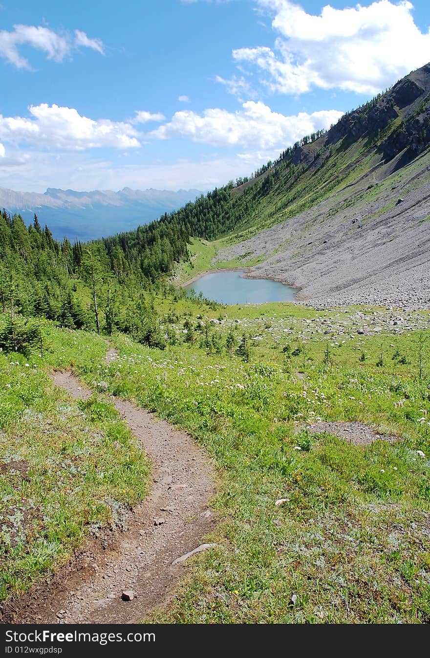 Alpine lake and meadows on mountains indefatigable, kananaskis country, alberta, canada