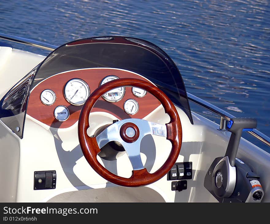 The motor boat wheel and control panel close up. The motor boat wheel and control panel close up.