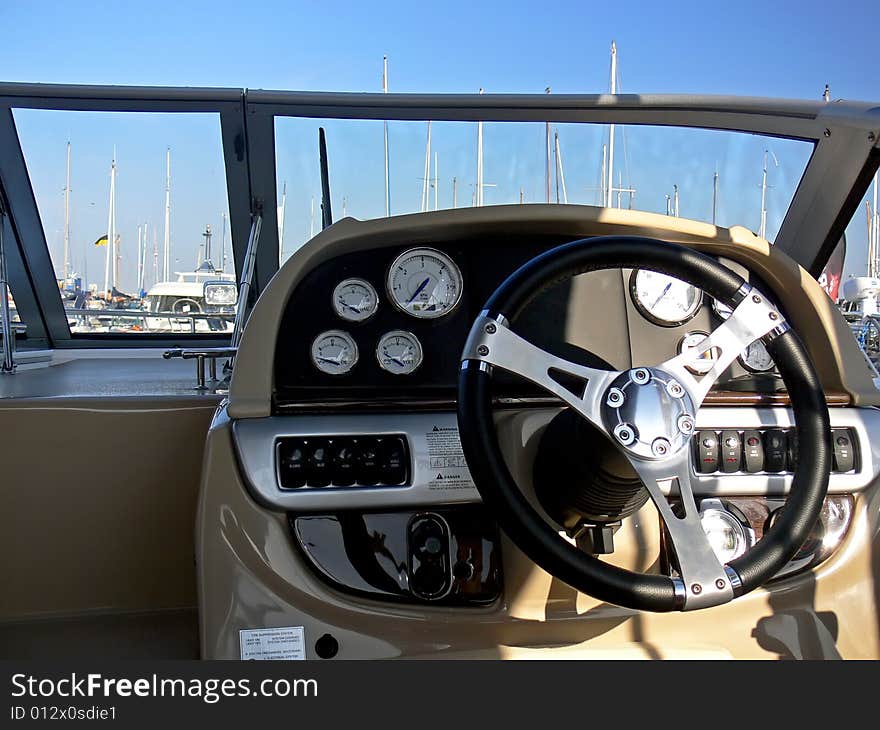 The motor boat wheel and control panel close up. The motor boat wheel and control panel close up.